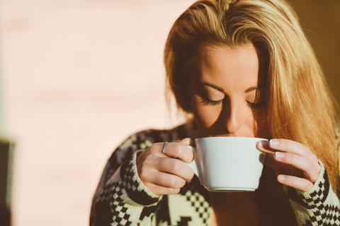A woman holding a white cup